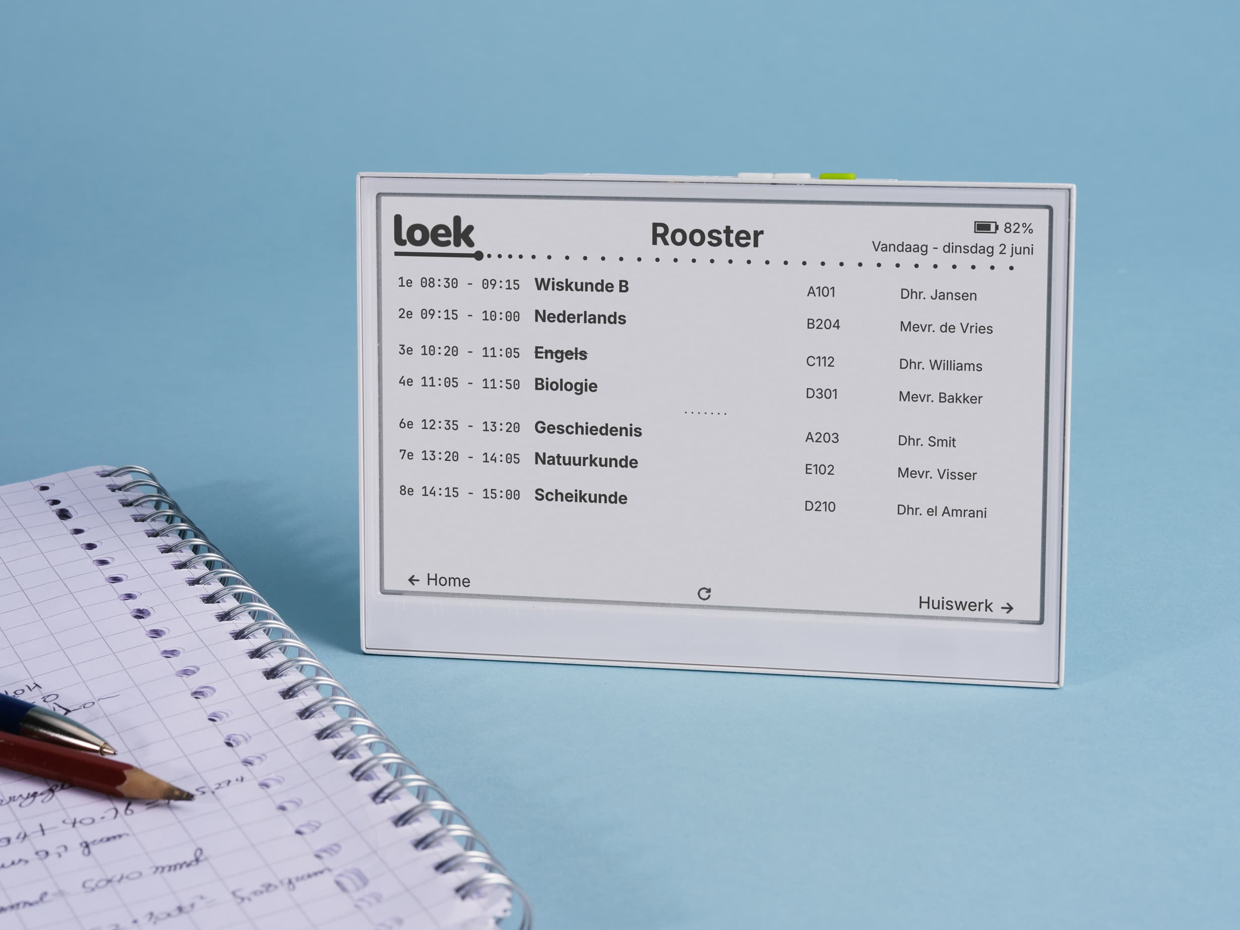 Loek op zijn standaard naast een schrift