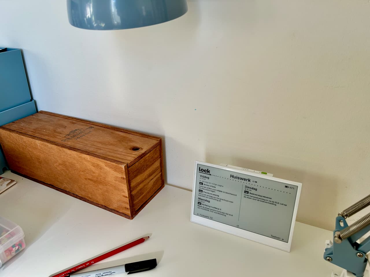 Loek op een bureau op de eigen kamer, naast een bureaulamp